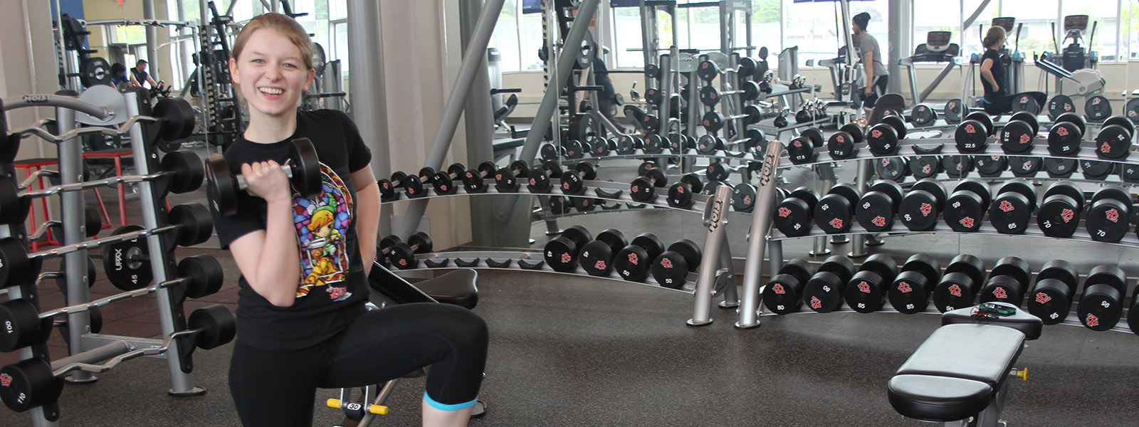 Image of student holding free weights in gym