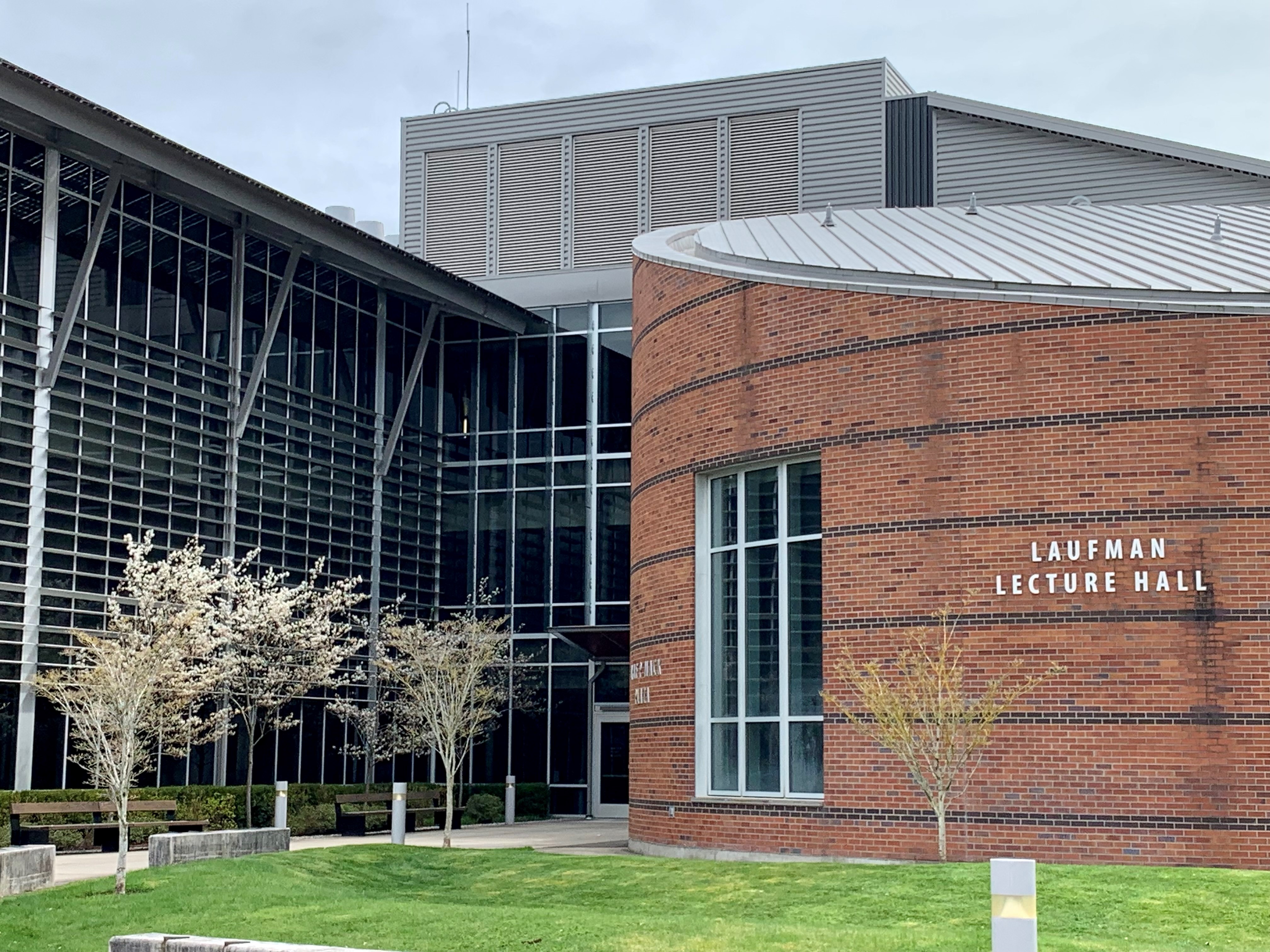 Health & Science Building Modern brick and glass architecture of the Health and Science building and Laufman Lecture Hall, surrounded by blooming trees and green landscaping.